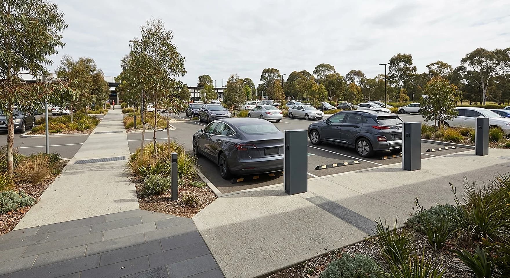 Two marked public charging bays with slim pedestals in a landscaped Joondalup civic and retail carpark